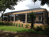 Mansard style pool enclosure with brick columns by East Coast Aluminum